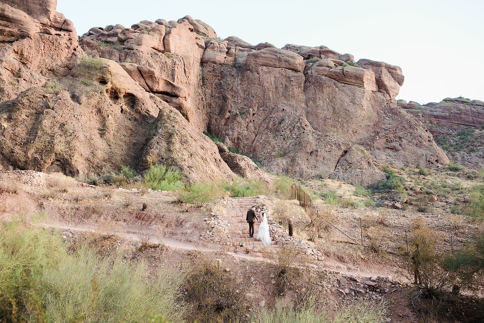 couple walks through echo canyon in wedding attire