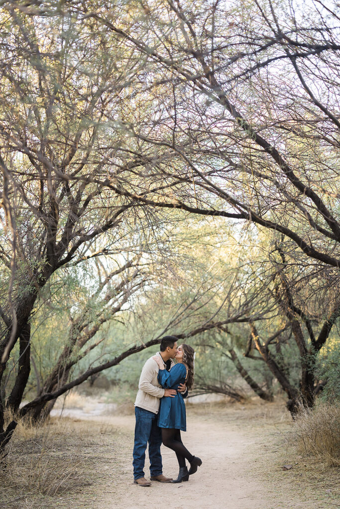 A couple embraces in the trees at Butcher Jones beach