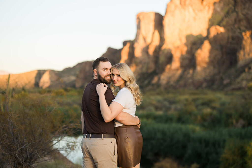 Couple embracing and looking back at the camera towards sunset at the Salt River basin