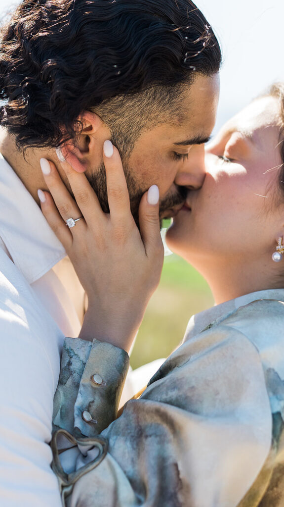 bride and groom kissing with bride holding his face