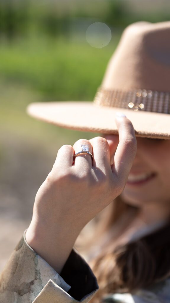 bride tipping hat with engagement ring