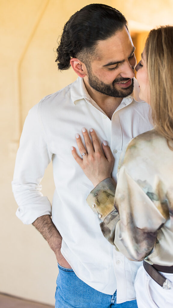 bride and groom embracing showing engagement ring