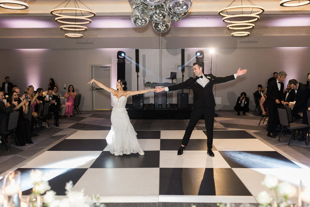bride and groom twirl on dance floor during first dance