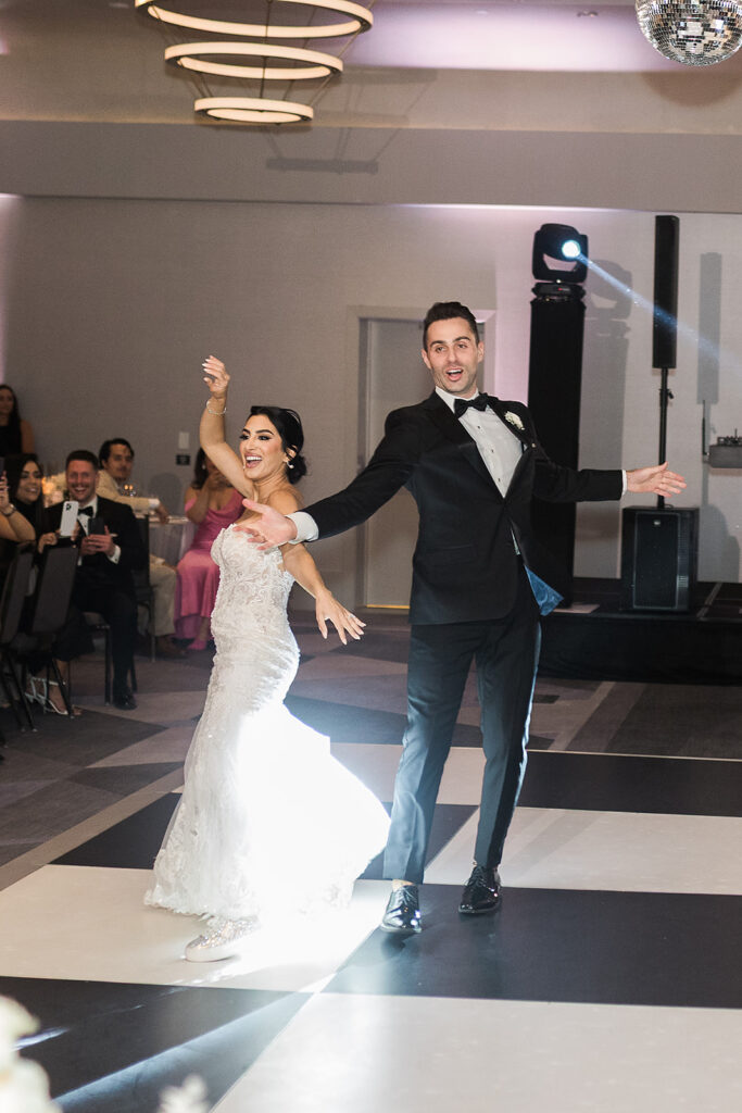 bride and groom twirl on dance floor during first dance