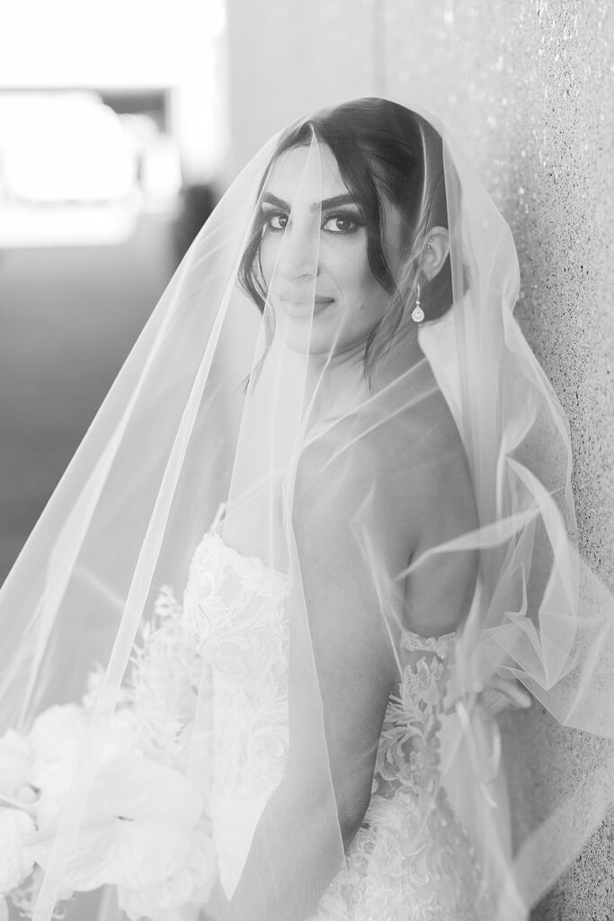 bride looks at camera from under veil